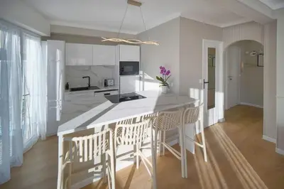 a kitchen with a large white island with chairs at Mimosa 2BR with Balcony - Walk to Palais and Beach in Cannes