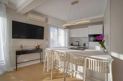 a kitchen with a island with bar stools at Mimosa 2BR with Balcony - Walk to Palais and Beach in Cannes
