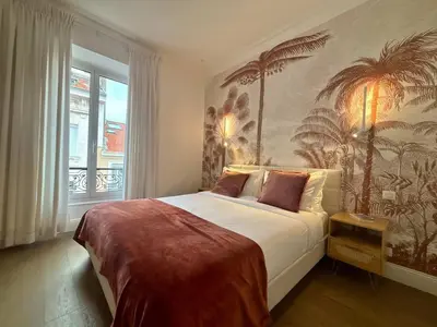 a kitchen with white cabinets and a table and chairs at SCARLETT 4 Bedroom next to the Croisette in Cannes