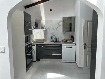 a white kitchen with a sink and a stove at Cannes centre ville en face du port in Cannes