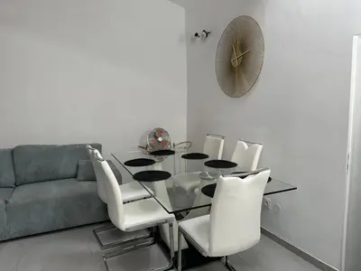 a dining room with a glass table and white chairs at Cannes centre ville en face du port in Cannes