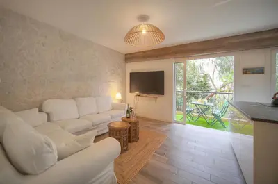a living room with a white couch and a tv at Calme 2 Chambres BALCON VUE JARDIN-CARNOT A2B266 in Cannes
