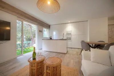 a kitchen and living room with a couch and a table at Calme 2 Chambres BALCON VUE JARDIN-CARNOT A2B266 in Cannes