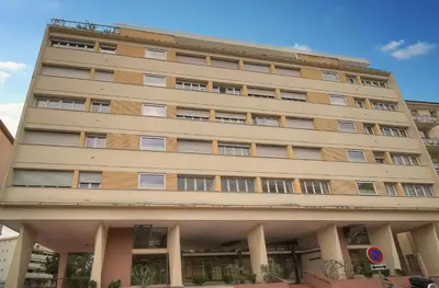 a tall tan building with many windows at Calme 2 Chambres BALCON VUE JARDIN-CARNOT A2B266 in Cannes