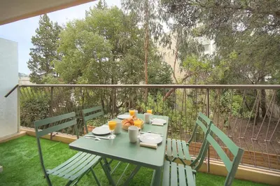 a table with plates of food and orange juice on a balcony at Calme 2 Chambres BALCON VUE JARDIN-CARNOT A2B266 in Cannes