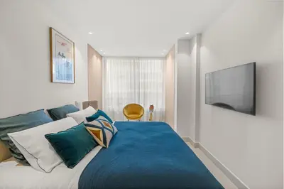 a bedroom with a blue bed with a flat screen tv at REF 2032 Renovated apartment-Sea view -Ideal for conferences and vacations in Cannes