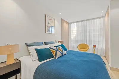 a bedroom with a bed with a blue blanket at REF 2032 Renovated apartment-Sea view -Ideal for conferences and vacations in Cannes