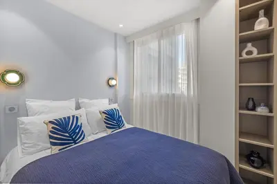 a bedroom with a bed with blue and white pillows at REF 2032 Renovated apartment-Sea view -Ideal for conferences and vacations in Cannes