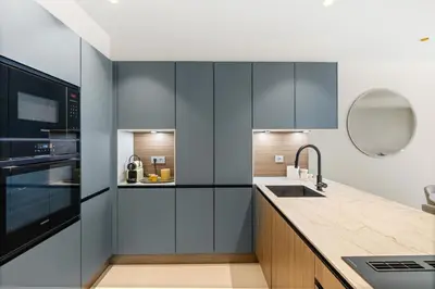 a kitchen with black and white cabinets and a sink at REF 2032 Renovated apartment-Sea view -Ideal for conferences and vacations in Cannes
