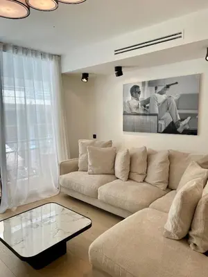 a living room with a couch and a glass table at T2 chic et moderne à deux pas de la Croisette in Cannes