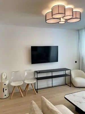 a living room with two chairs and a flat screen tv at T2 chic et moderne à deux pas de la Croisette in Cannes