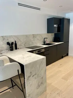 a kitchen with a marble counter and chairs in it at T2 chic et moderne à deux pas de la Croisette in Cannes