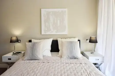 a bedroom with a bed with white pillows and two lamps at Résidence Cannes - 3p Neuf à 15min à Pied De La Plage - CANNES - 3P neuf à 15min à pied de la plage MAE-2383 in Cannes