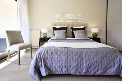 a bedroom with a large bed and a chair at Résidence Cannes - 3p Neuf à 15min à Pied De La Plage - CANNES - 3P neuf à 15min à pied de la plage MAE-2383 in Cannes