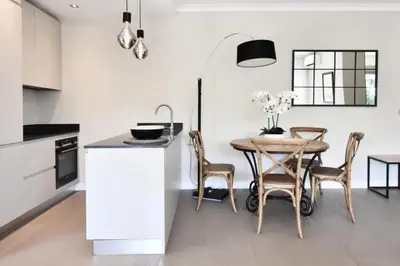 a kitchen with a table and chairs in a room at Résidence Cannes - 3p Neuf à 15min à Pied De La Plage - CANNES - 3P neuf à 15min à pied de la plage MAE-2383 in Cannes