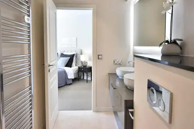 a bathroom with a sink and a toilet and a bedroom at Résidence Cannes - 3p Neuf à 15min à Pied De La Plage - CANNES - 3P neuf à 15min à pied de la plage MAE-2383 in Cannes