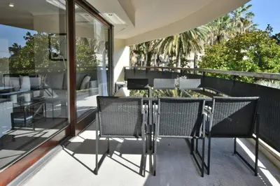 an outdoor patio with chairs and a table on a balcony at Résidence Cannes - 3p Neuf à 15min à Pied De La Plage - CANNES - 3P neuf à 15min à pied de la plage MAE-2383 in Cannes