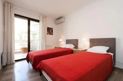 a bedroom with two beds with red sheets and a window at Résidence 3p Avec Terrasse Au Palm Beach, à 2min Des Plages - 3P avec terrasse au Palm Beach, à 2min des plages MAE-1553 in Cannes