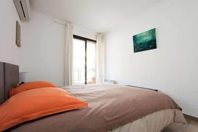 a bedroom with a bed with orange pillows on it at Résidence 3p Avec Terrasse Au Palm Beach, à 2min Des Plages - 3P avec terrasse au Palm Beach, à 2min des plages MAE-1553 in Cannes