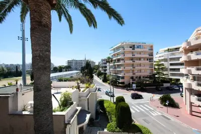 a palm tree on a city street with buildings at Résidence 3p Avec Terrasse Au Palm Beach, à 2min Des Plages - 3P avec terrasse au Palm Beach, à 2min des plages MAE-1553 in Cannes
