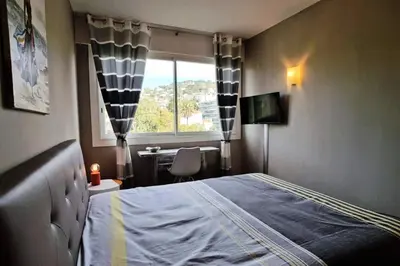 a bedroom with a bed and a window and a desk at Résidence 4p Terrasse & Vue Mer, Plage à 5 Min - 4P terrasse & vue mer, plage à 5 min MAE-1563 in Cannes
