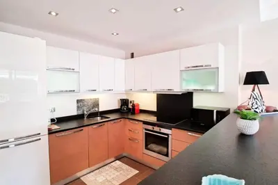 a kitchen with white cabinets and a black counter top at Résidence 4p Terrasse & Vue Mer, Plage à 5 Min - 4P terrasse & vue mer, plage à 5 min MAE-1563 in Cannes