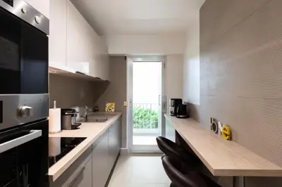 a kitchen with white counters and a large window at Résidence 3p Traversant à 2 Min Des Plages, Parking Privé - 3P traversant à 2 min des plages, parking privé MAE-1583 in Cannes