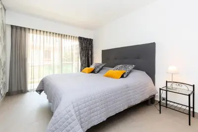 a bedroom with a large bed with yellow pillows at Résidence 3p Traversant à 2 Min Des Plages, Parking Privé - 3P traversant à 2 min des plages, parking privé MAE-1583 in Cannes