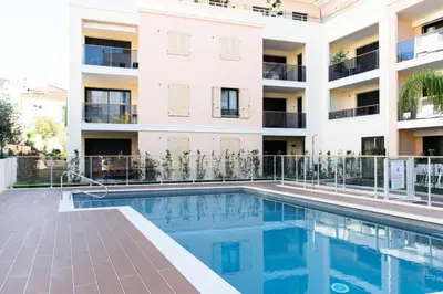 an apartment with a swimming pool in front of a building at Résidence 3p Avec Terrasse Et Piscine Au Coeur Du Palm Beach - 3P avec terrasse et piscine au coeur du Palm Beach MAE-1593 in Cannes
