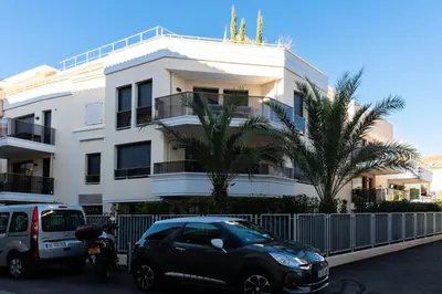 a black car parked in front of a white building at Résidence 3p Avec Terrasse Et Piscine Au Coeur Du Palm Beach - 3P avec terrasse et piscine au coeur du Palm Beach MAE-1593 in Cannes