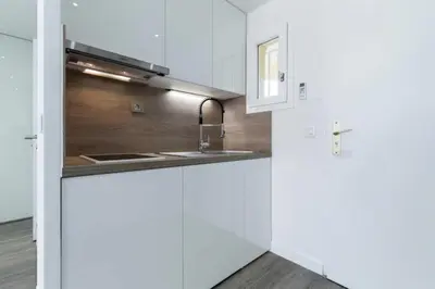 a kitchen with white cabinets and a sink at Résidence Havre De Paix 2 Pièces, Terrasse Vue Mer & Piscine - Havre de paix 2 pièces, terrasse vue mer & piscine MAE-1603 in Cannes
