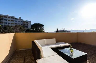 a white couch and a table on a balcony at Résidence Havre De Paix 2 Pièces, Terrasse Vue Mer & Piscine - Havre de paix 2 pièces, terrasse vue mer & piscine MAE-1603 in Cannes