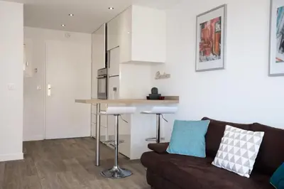 a living room with a couch and a kitchen at Résidence Havre De Paix 2 Pièces, Terrasse Vue Mer & Piscine - Havre de paix 2 pièces, terrasse vue mer & piscine MAE-1603 in Cannes