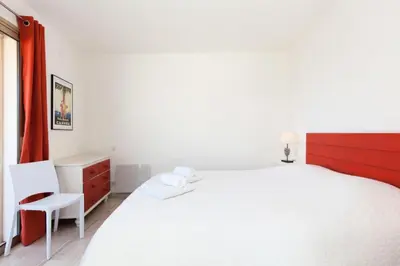 a white bedroom with a large white bed and a chair at Résidence 3p De Standing, Vue Mer Et Grande Terrasse - 3P de standing, vue mer et grande terrasse MAE-1613 in Cannes