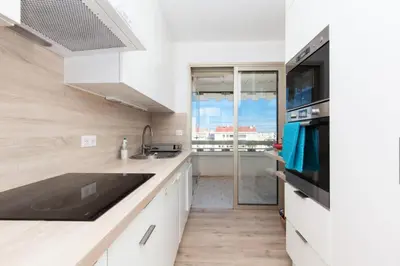 a kitchen with white cabinets and a large window at Résidence 3p De Standing, Vue Mer Et Grande Terrasse - 3P de standing, vue mer et grande terrasse MAE-1613 in Cannes