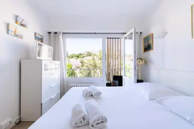 a white bedroom with two beds and a window at Résidence 3p Cosy, 6 Minutes à Pied Des Plages - 3P cosy, 6 minutes à pied des plages MAE-1633 in Cannes