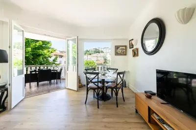 a living room with a television and a table with chairs at Résidence 3p Cosy, 6 Minutes à Pied Des Plages - 3P cosy, 6 minutes à pied des plages MAE-1633 in Cannes