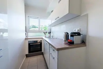 a kitchen with white cabinets and a sink and a window at Résidence 3p Cosy, 6 Minutes à Pied Des Plages - 3P cosy, 6 minutes à pied des plages MAE-1633 in Cannes
