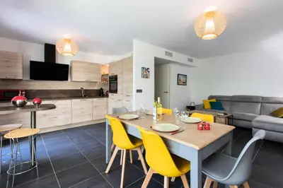 a kitchen and living room with a table and yellow chairs at Résidence 3p Avec Jardin Et Piscine Au Coeur Du Palm Beach - 3P avec jardin et piscine au coeur du Palm Beach MAE-1643 in Cannes