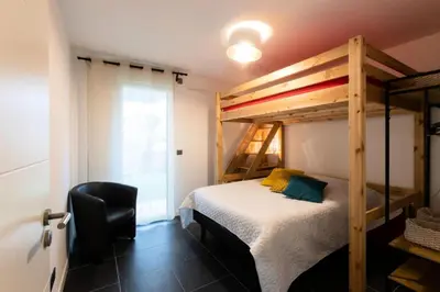 a bedroom with a bunk bed and a chair at Résidence 3p Avec Jardin Et Piscine Au Coeur Du Palm Beach - 3P avec jardin et piscine au coeur du Palm Beach MAE-1643 in Cannes