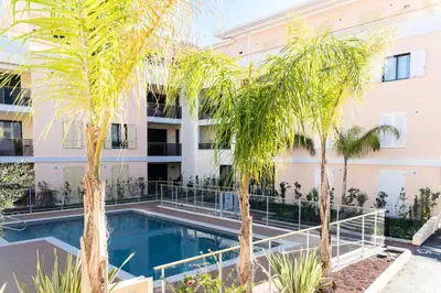 a swimming pool in front of a building with palm trees at Résidence 3p Avec Jardin Et Piscine Au Coeur Du Palm Beach - 3P avec jardin et piscine au coeur du Palm Beach MAE-1643 in Cannes