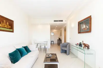 a living room with a white couch and a table at Résidence Vue Mer, Cannes Croisette, Au Pied Des Plages - Vue Mer, Cannes Croisette, au Pied des Plages MAE-1653 in Cannes