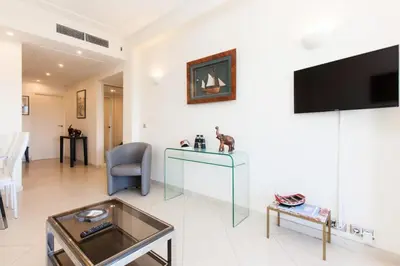 a living room with a glass table and a tv at Résidence Vue Mer, Cannes Croisette, Au Pied Des Plages - Vue Mer, Cannes Croisette, au Pied des Plages MAE-1653 in Cannes