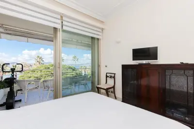 a bedroom with a bed and a television and a balcony at Résidence Vue Mer, Cannes Croisette, Au Pied Des Plages - Vue Mer, Cannes Croisette, au Pied des Plages MAE-1653 in Cannes