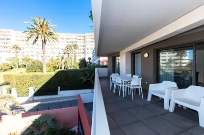 a patio with white chairs and tables on a balcony at Résidence 3p Terrasse Et Piscine à 15min à Pied Du Palais - 3P terrasse et piscine à 15min à pied du Palais MAE-1663 in Cannes
