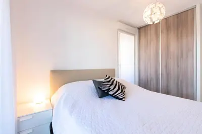 a bedroom with a white bed with a pillow on it at Résidence 3p Terrasse Et Piscine à 15min à Pied Du Palais - 3P terrasse et piscine à 15min à pied du Palais MAE-1663 in Cannes