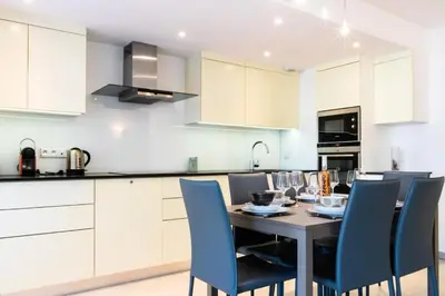 a kitchen with a table and blue chairs at Résidence 3p Terrasse Et Piscine à 15min à Pied Du Palais - 3P terrasse et piscine à 15min à pied du Palais MAE-1663 in Cannes