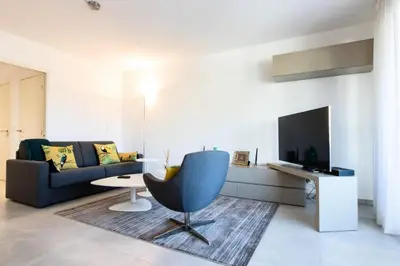 a living room with a couch and a chair at Résidence 3p Terrasse Et Piscine à 15min à Pied Du Palais - 3P terrasse et piscine à 15min à pied du Palais MAE-1663 in Cannes