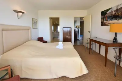 a hotel room with a large bed and a desk at Résidence 3p Proche Centre Ville, Piscine Et Vue Mer - 3P proche centre ville, piscine et vue mer MAE-1673 in Cannes