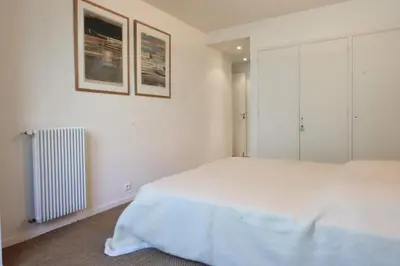 a white bedroom with a bed and a radiator at Résidence 3p Proche Centre Ville, Piscine Et Vue Mer - 3P proche centre ville, piscine et vue mer MAE-1673 in Cannes